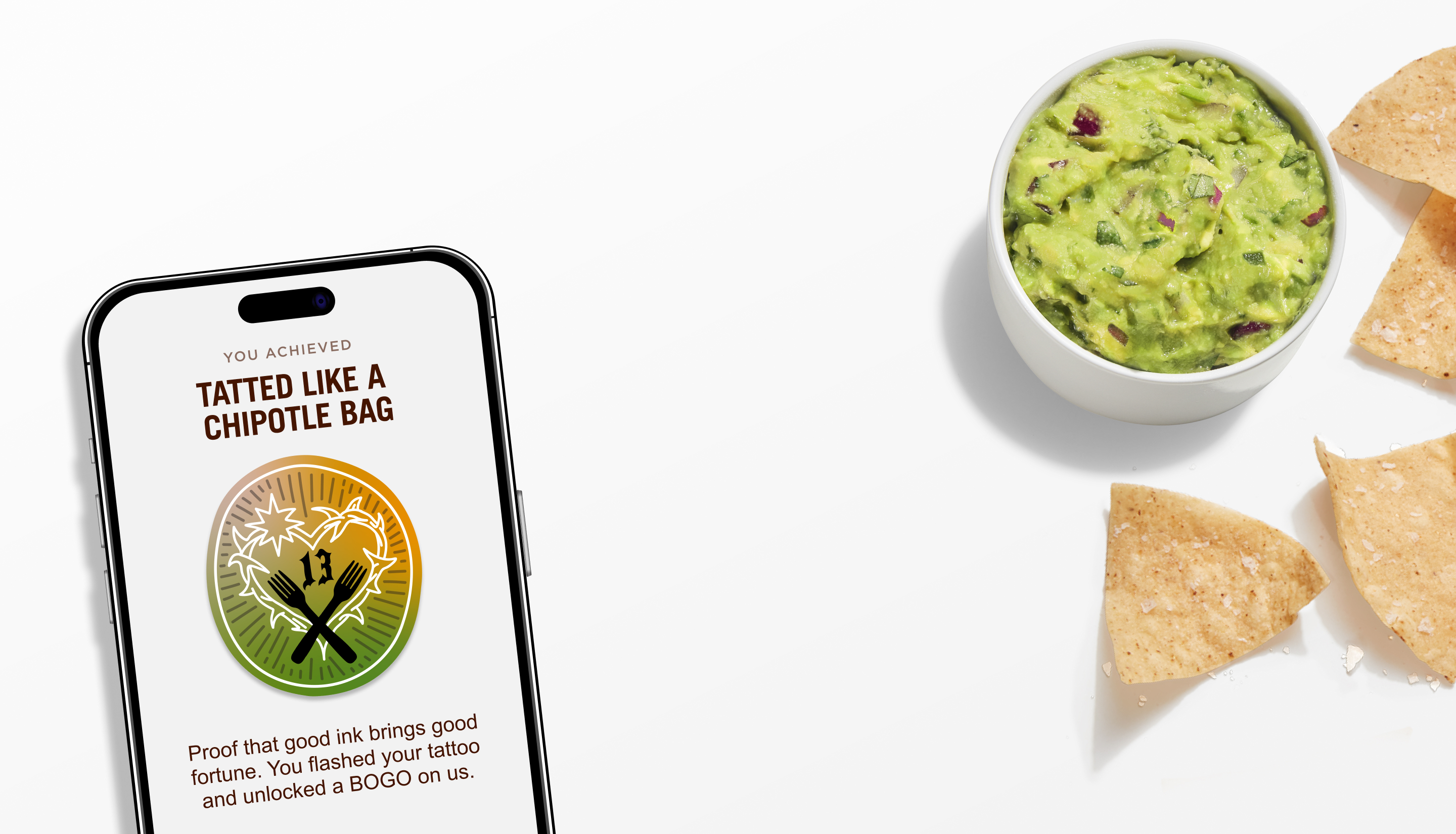 A side of freshly made Guacamole and Tortilla Chips laying beside a phone with the Tattoo BOGO Extra Badge.